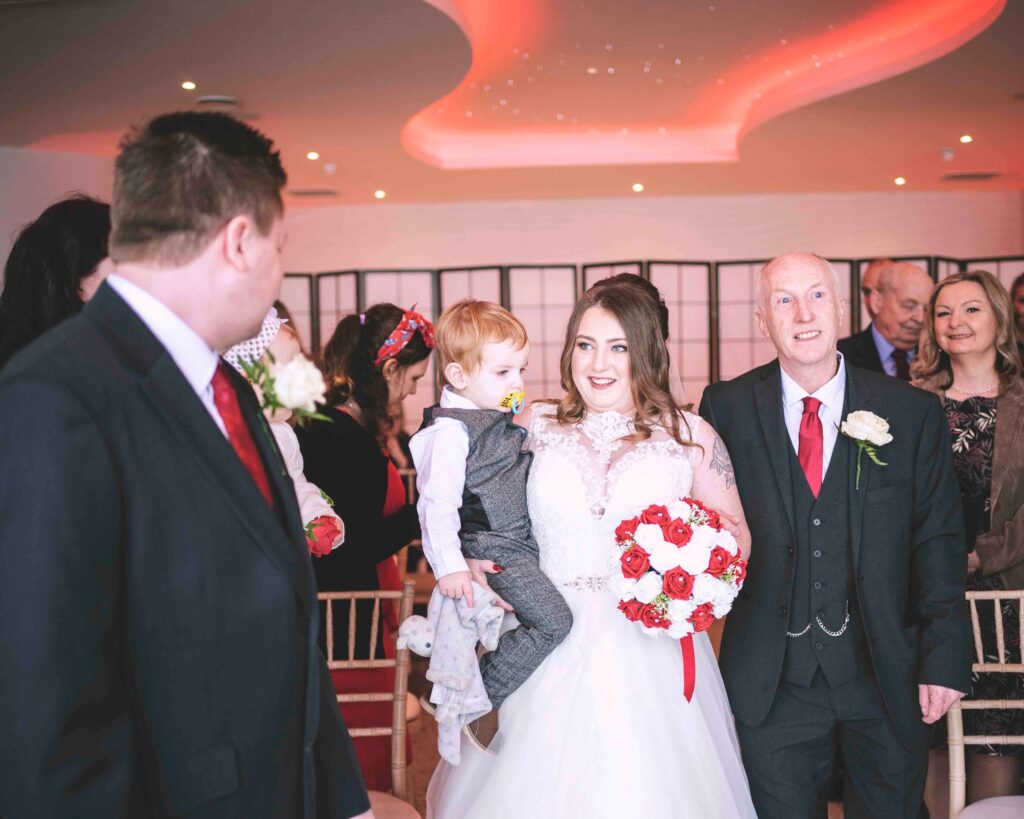 Bride, son and father walking up the aisle at Sandy Cove Hotel wedding
